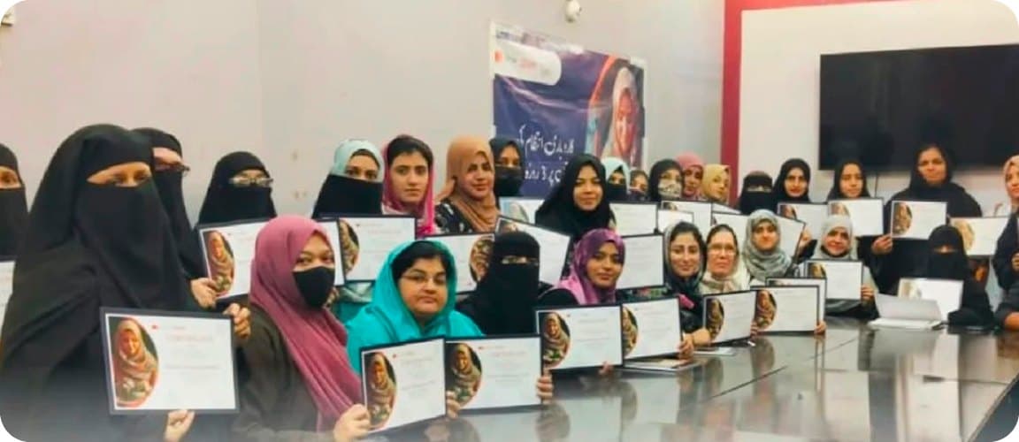 A hall of graduates holding their certificates at a Pak British award ceremony