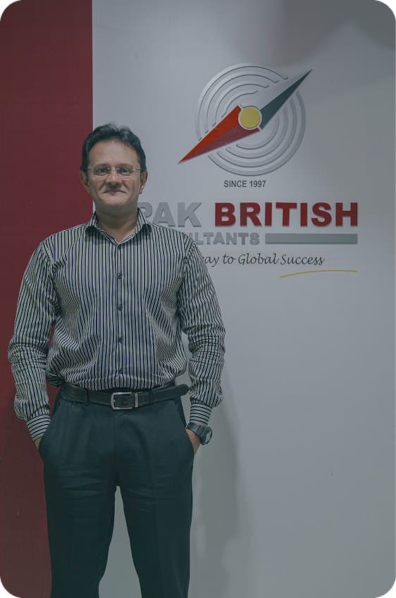 A team member beside the Pak British Consultants signage
