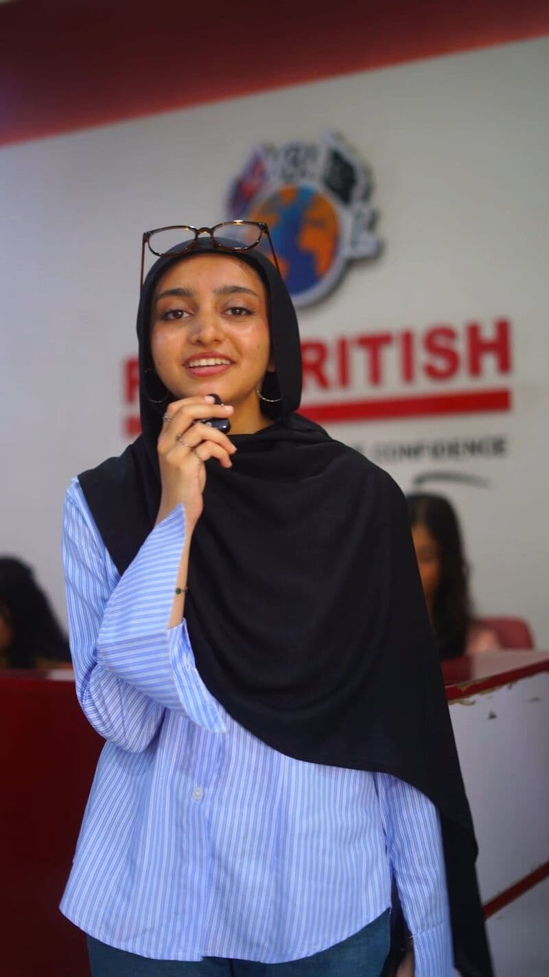 A student speaking in front of the Pak British brand wall